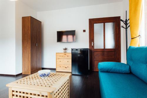 - un salon avec un canapé bleu et un réfrigérateur noir dans l'établissement Szitas Rooms, à Praid