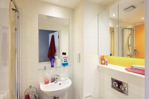 uma casa de banho branca com um lavatório e um espelho em For Students Only Private Bedrooms with Shared Kitchen at Riverside Way in Winchester em Winchester