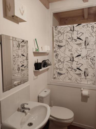 a bathroom with a sink and a toilet and a shower curtain at NAMOR-Apartamento Tres Balcones in Ribadeo