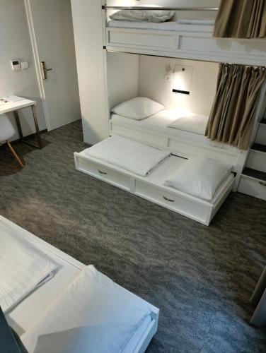 a room with two bunk beds and a desk at Downtown Boutique Hostel in Zadar