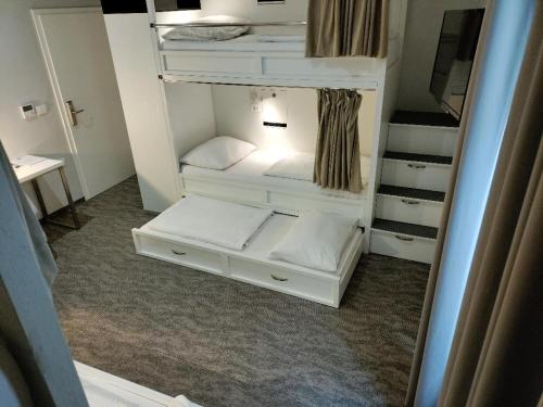 a small room with white bunk beds in it at Downtown Boutique Hostel in Zadar