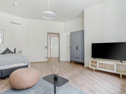 a bedroom with a bed and a flat screen tv at Limehome Leipzig Oelßner's Hof in Leipzig