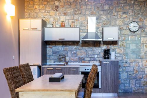 a kitchen with a table and a stone wall at River country in Kalavrita