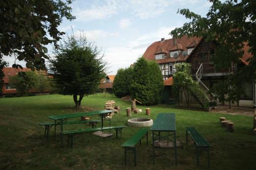 einem Park mit grünen Picknicktischen und einem Gebäude in der Unterkunft Hofraithe Park in Rosenthal