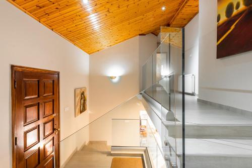 a glass staircase in a house with a wooden ceiling at Pinecone Platres - 3 Units in Platres