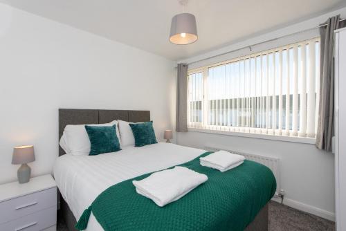 a bedroom with a bed with two towels on it at Cornsay in Stockton-on-Tees