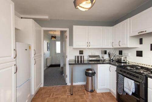 a kitchen with white cabinets and a counter top at Cornsay in Stockton-on-Tees