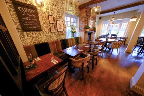 a restaurant with tables and chairs in a room at Governors House by Greene King Inns in Cheadle Hulme