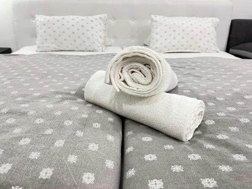 a rolled up towel sitting on a bed at Aqua Wellness Apartments in Hajd&uacute;szoboszl&oacute;