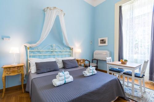 ナポリにあるCasAlice Mini Apartments Napoliの青いベッドルーム(タオル付きのベッド付)