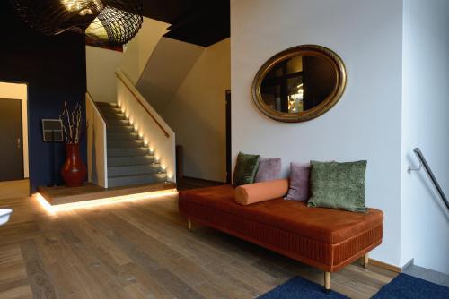 a living room with a couch and a mirror at Hotel Profis in Diepoldsau