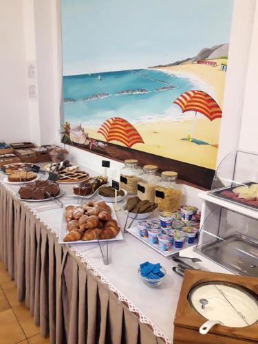 a buffet line with food on a table at Hotel Caesar in Pesaro