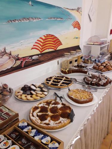 a buffet of pies and desserts on a table at Hotel Caesar in Pesaro
