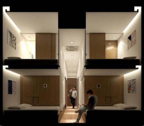 a man is sitting in a room with beds at Play Poshtel & Cafe' in Krabi town