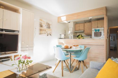 une cuisine et un salon avec une table et des chaises dans l'établissement Escale à deux au coeur de l'île de Ré - La Rétaise, à Saint-Martin-de-Ré