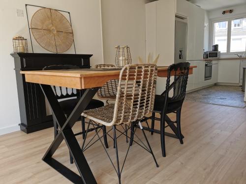 une table de salle à manger avec des chaises et une cuisine dans l'établissement L'EMILIO - hypercentre, lumineux et vue Loire, à Blois