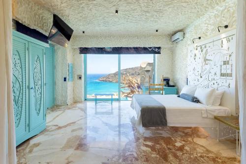 a bedroom with a bed and a view of the ocean at Calilo in Manganari