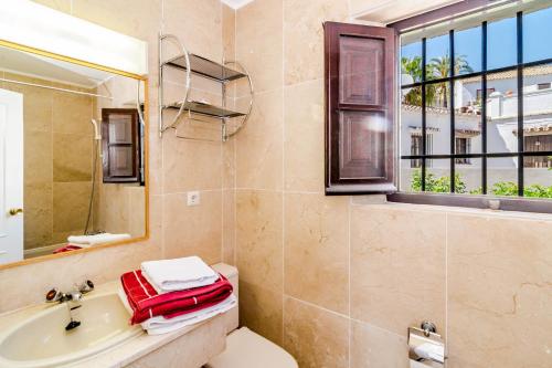 a bathroom with a toilet and a sink and a mirror at EN- Cozy Andalusian style townhouse in Marbella in Marbella