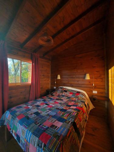 a bedroom with a bed in a log cabin at Cabañas Amo Río - Delta in Tigre