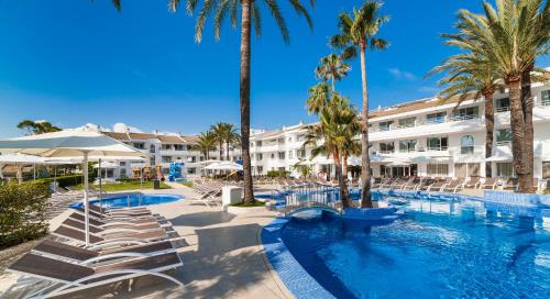 
a hotel room with a pool and a beach at Hoposa Hotel & Apartaments VillaConcha in Port de Pollensa
