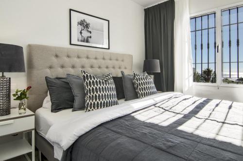 ein Schlafzimmer mit einem großen Bett mit Kissen darauf in der Unterkunft RDM - Stylish Holiday Apartment with Ocean Views in Mijas