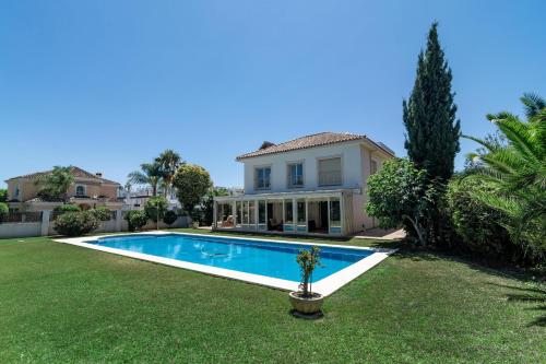 a house with a swimming pool in a yard at CLN- Spacious 6 bedroom villa next to beach in Marbella