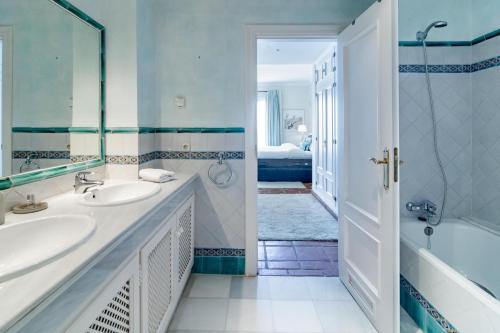 a bathroom with two sinks and a tub and a shower at LAP- 3 bed apartment on the beach. Families only in Casares