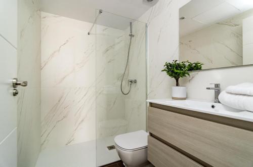 a bathroom with a shower and a toilet and a sink at DJC - Modern 2 bedroom apartment close to beach in Casares