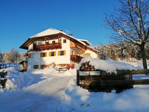 una casa cubierta de nieve delante en Haus Pichler Apartment en Collalbo