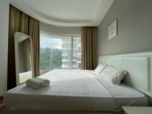 a bedroom with a large bed with two towels on it at Sky Bungalow NIlai by James NEARBY KLIA, KLIA 2, CYBERJAYA, PUTRAJAYA in Nilai
