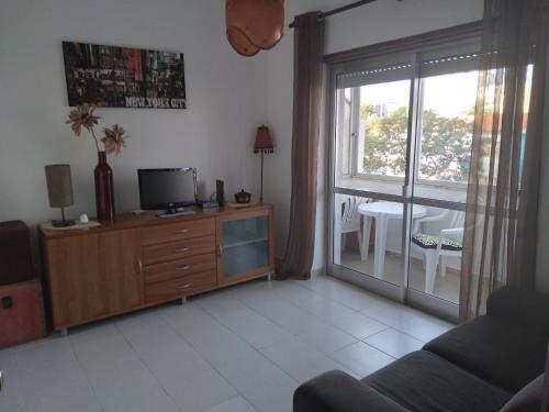 a living room with a tv on a dresser and a window at Casa do MIGUEL- 2 BEDROOM APARTMENT in Faro
