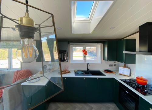 a kitchen with green cabinets and a sink at Mawgan Pads Padstow in Padstow