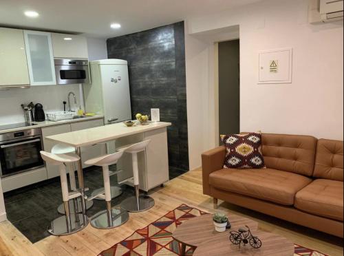 Il dispose d'une cuisine et d'un salon avec un canapé et une table. dans l'établissement Chiado/Bairro Alto 2 bedroom apartment, à Lisbonne