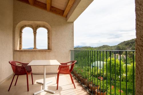 a balcony with a table and chairs and a view at Can Alemany in Santa Margarida de Montbui