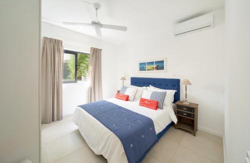 a bedroom with a blue bed and a window at Nautilya Apartment by LOV in Pointe aux Cannoniers