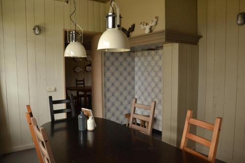 a dining room with a black table and chairs at Vakantiewoning Boerderij De Gerrithoeve in Oisterwijk
