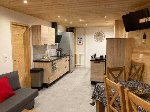 Great 8-pax ski-in ski-out apartment in Tignes Val Claret في تينيِ: مطبخ مع أريكة وطاولة في الغرفة
