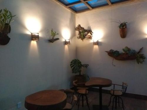 een kamer met twee tafels en wat planten aan de muur bij Café Palace Hotel in Três Pontas