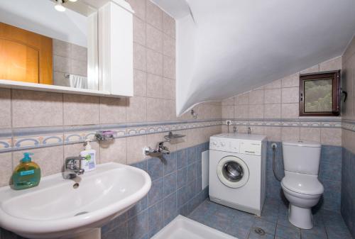 een badkamer met een wastafel en een wasmachine bij Villa Dimosthenis in Stalós