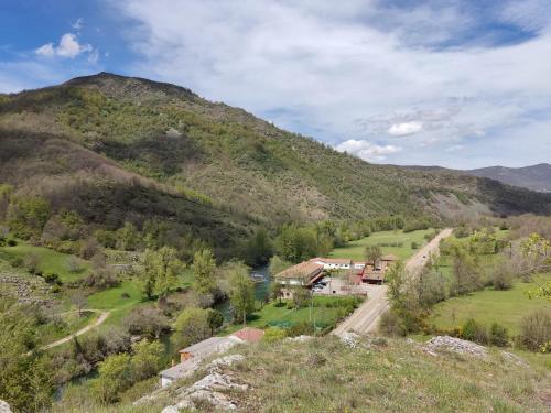 una casa en un valle con una montaña en Hostal Restaurante Ventasierra, en Valdoré