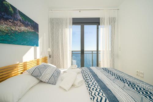 a bedroom with a bed with a large window at Casa Vistamar in Altea