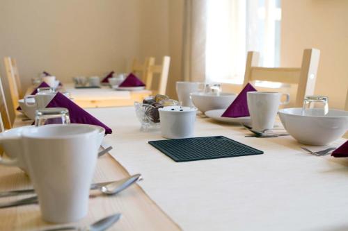 a long table with white cups and utensils on it at Cahermaclanchy House in Doolin