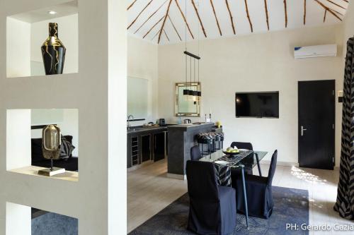 a kitchen and dining room with a dining table and a living room at Villa Le Petit Paradis Saly Boutique Hotel in Ngaparou