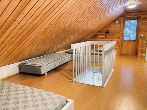 a attic room with two beds and a wooden ceiling at Lomasärkkä1 in Kalajoki