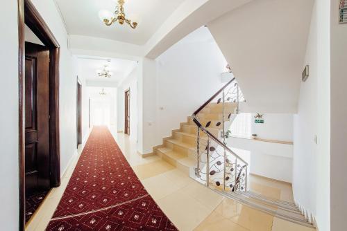 a hallway with stairs and a red rug at Pension Elegance in Gura Humorului