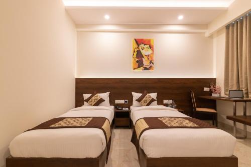 a hotel room with three beds and a desk at Mojatel By Icon in Bengaluru