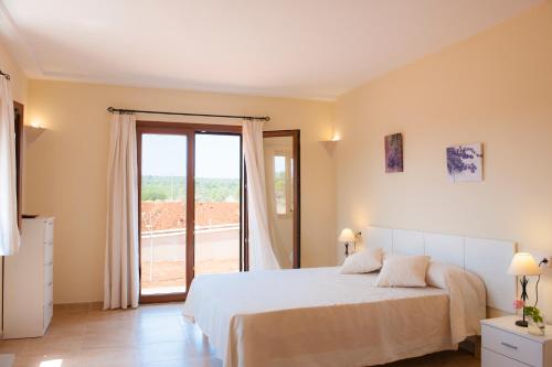 a bedroom with a bed and a large window at Finca Xorca in Caʼs Concos