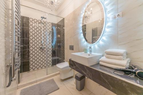 een badkamer met een wastafel, een toilet en een spiegel bij Music Academy Bedroom Suite Café Vian Apartman Kft in Boedapest