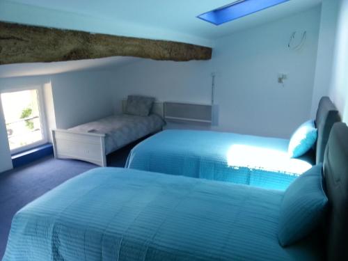 une chambre d'hôtel avec deux lits et un canapé dans l'établissement Le Gîte du Port, à Saint-Pierre-de-Boeuf