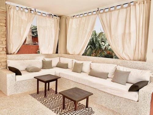a living room with a white couch and two tables at Villa Le Petit Paradis Saly Boutique Hotel in Ngaparou